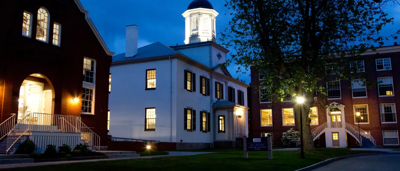 exterior of three buildings at night on the u n e portland campus